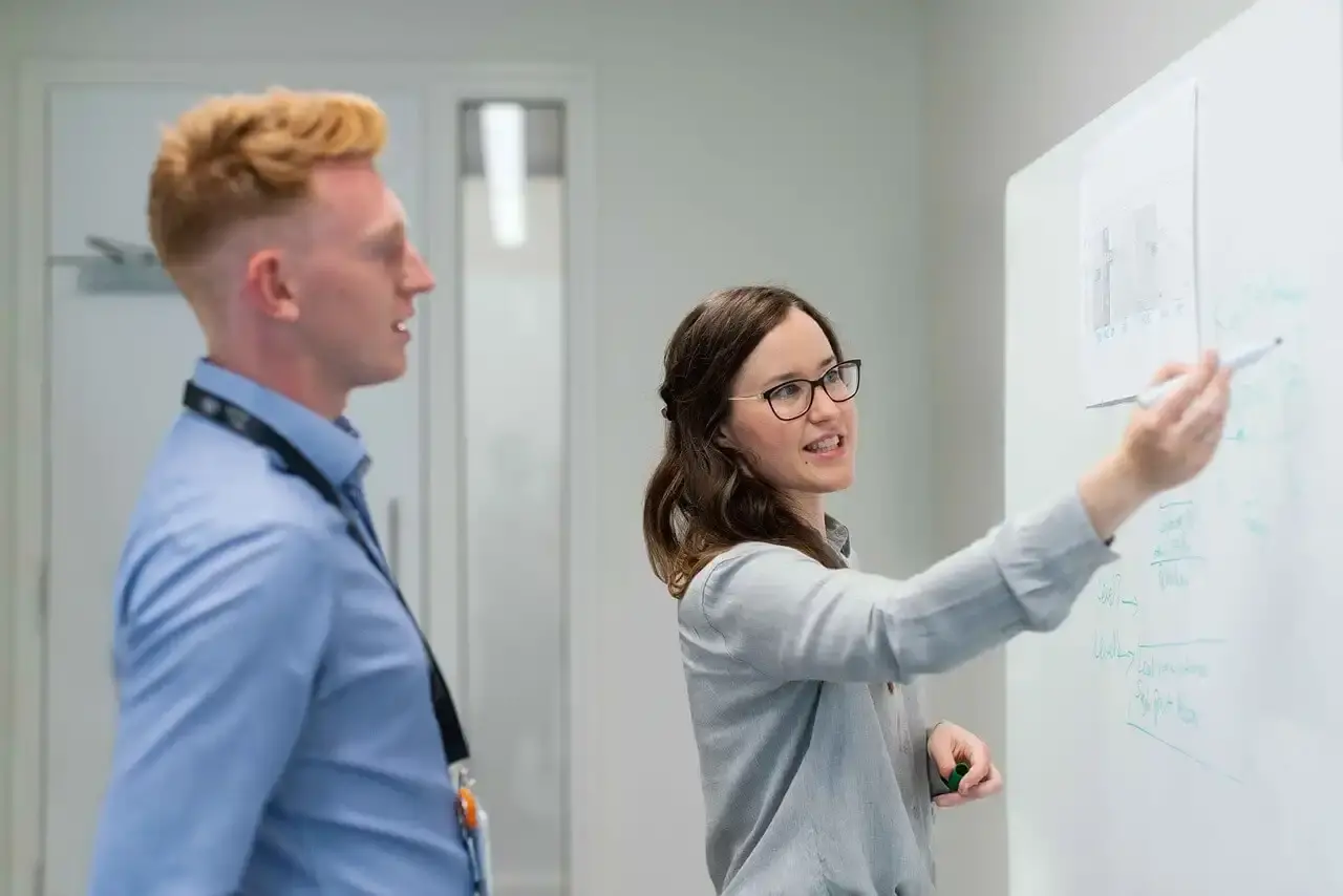 Mitarbeiter bei einer Besprechung am Whiteboard