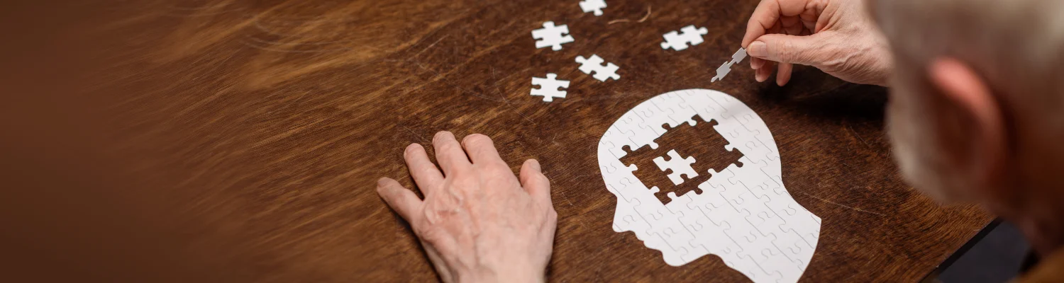 Banner, alter Mann macht ein Kopfpuzzle in dem ein paar Stücke fehlen