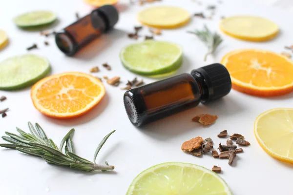 Orangen- und Limettenscheiben, Kräuter und Ölfläschchen