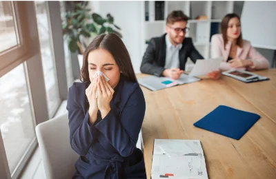 Frau benutzt ein Taschentuch im Meeting
