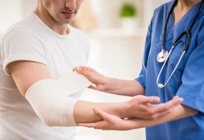 Ärztin legt Verband am Ellenbogen an